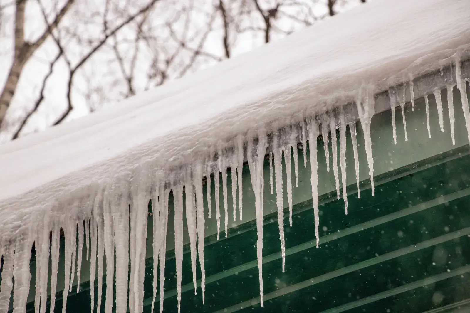 Icicles hanging from a snow-covered roof edge