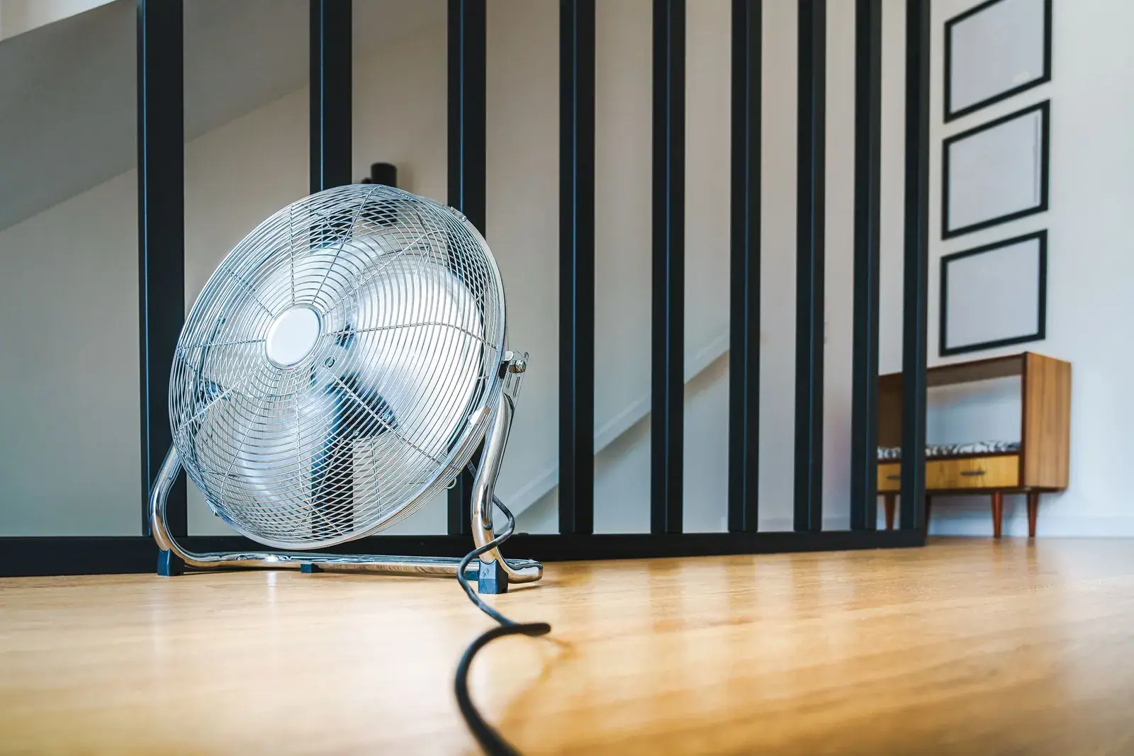 Large floor fan standing on a hardwood floor